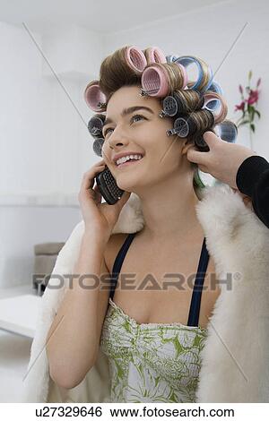 Model on Cell Phone While Having Hair Curled View Large Photo Image Stock Photograph - Model on Cell Phone While Having Hair Curled. Fotosearch