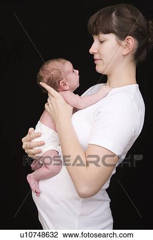 Modern holding her newborn baby studio shot View Large Photo Image Stock Image - Modern holding her newborn baby studio shot. Fotosearch