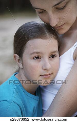 Stock Image - Mother embracing her daughter close-up. Fotosearch