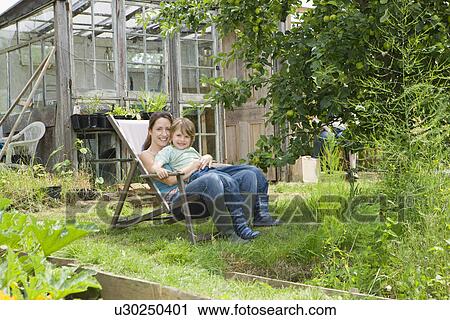 Mother sitting with son in garden portrait View Large Photo Image Stock Image - Mother sitting with son in garden portrait. Fotosearch