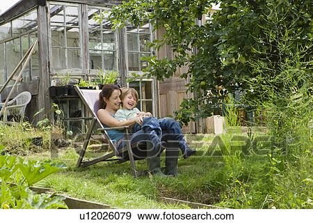 Stock Photo - Mother sitting with son in garden. Fotosearch