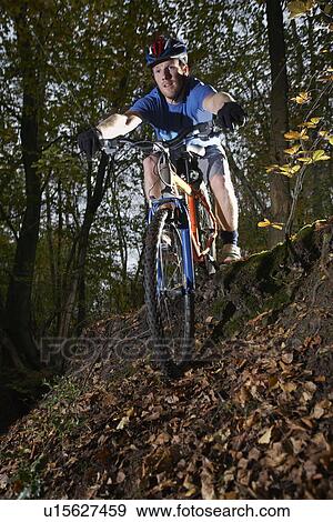 Stock Photo - Mountain biker in woodland. Fotosearch
