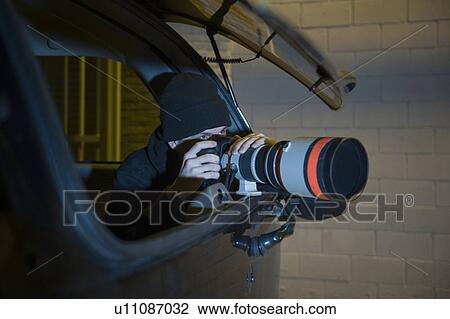 Stock Image - Paparazzi photographer in car. Fotosearch