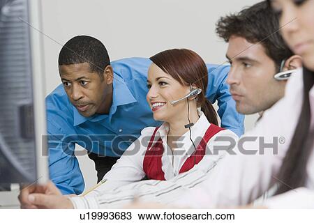 Stock Image - People Wearing Headsets in Office. Fotosearch