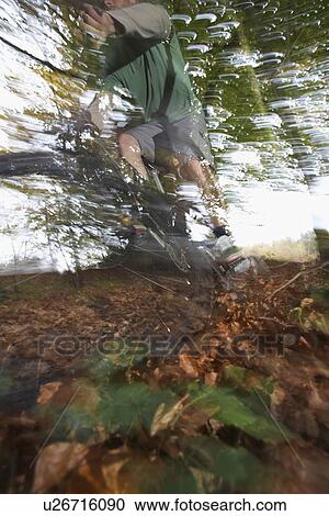 Stock Image - Person on mountain bike in countryside. Fotosearch
