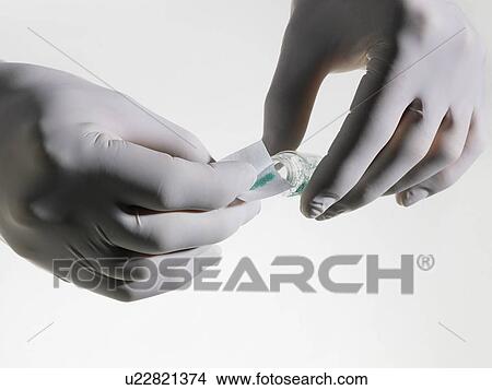 Person wearing rubber gloves putting powder into vial close up studio shot View Large Photo Image Picture - Person wearing rubber gloves putting powder into vial close up studio shot. Fotosearch