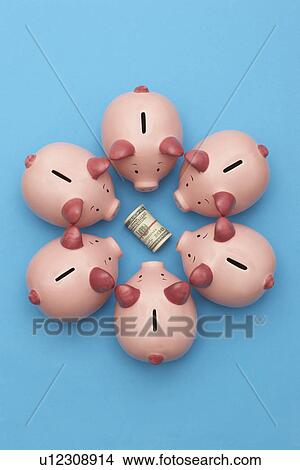 Piggy banks surrounding roll of dollar bills blue background view from above View Large Photo Image Picture - Piggy banks surrounding roll of dollar bills blue background view from above. Fotosearch