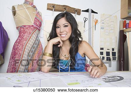 Portrait of female fashion designer working at desk View Large Photo Image Stock Image - Portrait of female fashion designer working at desk. Fotosearch