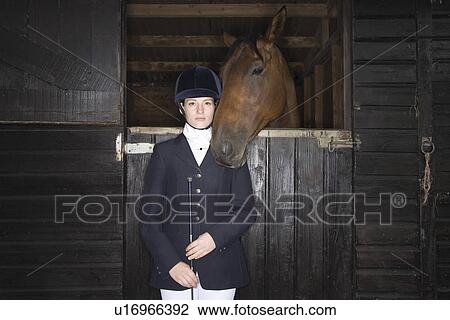 Portrait of Female horseback rider with horse in stable View Large Photo Image Stock Image - Portrait of Female horseback rider with horse in stable. Fotosearch