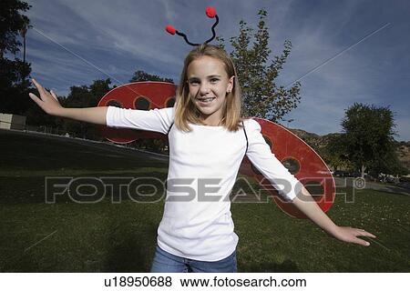 Stock Photo - Portrait of girl (10-12) wearing ladybug costume. Fotosearch