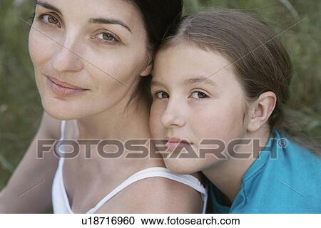 Stock Image - Portrait of girl embracing her mother close-up. Fotosearch