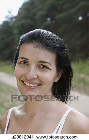 Stock Image - Portrait of mid-adult woman smiling close-up. Fotosearch