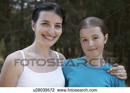 Stock Image - Portrait of mother embracing her daughter outdoors. Fotosearch
