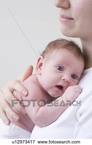 Portrait of newborn baby held by his/her mother studio shot View Large Photo Image Stock Photo - Portrait of newborn baby held by his/her mother studio shot. Fotosearch