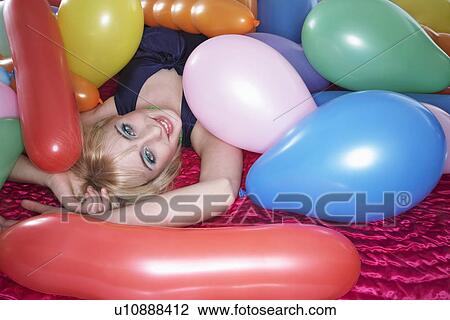 Portrait of teenage girl (16-17) lying on bed under pile of balloons View Large Photo Image Stock Image - Portrait of teenage girl (16-17) lying on bed under pile of balloons. Fotosearch