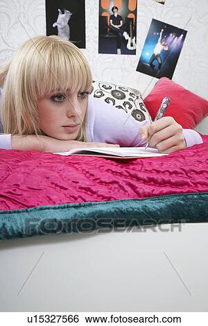 Portrait of teenager (16-17) lying on bed writing diary View Large Photo Image Stock Photograph - Portrait of teenager (16-17) lying on bed writing diary. Fotosearch