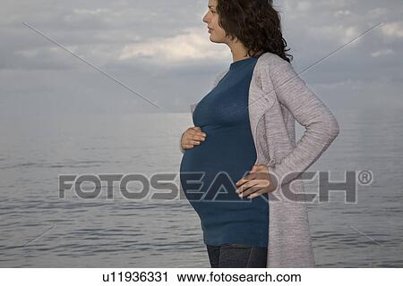 Stock Image - Pregnant woman at ocean. Fotosearch