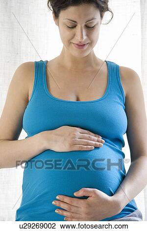 Pregnant woman holding stomach View Large Photo Image Stock Image - Pregnant woman holding stomach. Fotosearch