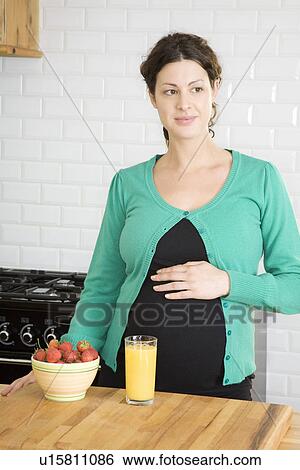 Pregnant woman in kitchen View Large Photo Image Stock Photograph - Pregnant woman in kitchen. Fotosearch