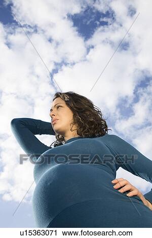 Pregnant woman outdoors low angle view View Large Photo Image Stock Image - Pregnant woman outdoors low angle view. Fotosearch