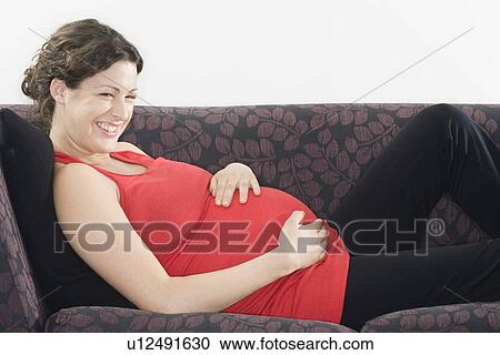 Pregnant woman relaxing on sofa View Large Photo Image Stock Image - Pregnant woman relaxing on sofa. Fotosearch