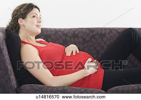 Pregnant woman relaxing on sofa View Large Photo Image Stock Image - Pregnant woman relaxing on sofa. Fotosearch