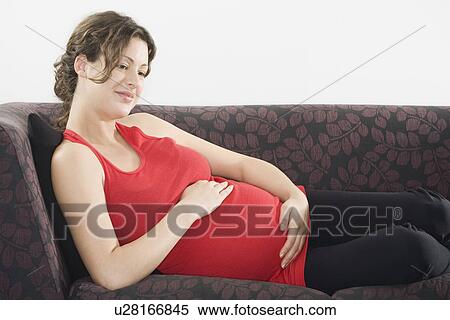 Pregnant woman relaxing on sofa View Large Photo Image Stock Photography - Pregnant woman relaxing on sofa. Fotosearch