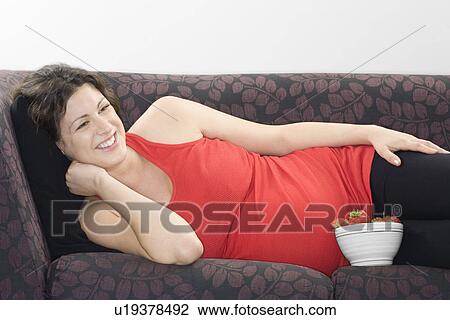 Pregnant woman with bowl of strawberries on sofa View Large Photo Image Stock Image - Pregnant woman with bowl of strawberries on sofa. Fotosearch