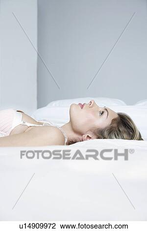 Profile of young woman in underwear lying on bed close-up View Large Photo Image Stock Image - Profile of young woman in underwear lying on bed close-up. Fotosearch
