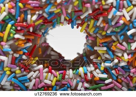 Stock Photograph - Rainbow sprinkles on doughnut close-up. Fotosearch