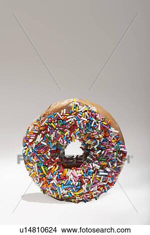 Picture - Rainbow sprinkles on doughnut. Fotosearch