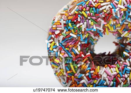 Picture - Rainbow sprinkles on doughnut. Fotosearch