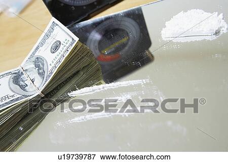 Stock Photo - Rows of cocaine on mirror and bundle of money. Fotosearch