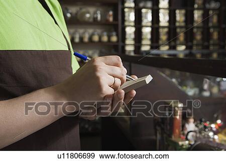 Salesperson Writing Order in Tea Shop View Large Photo Image Stock Photo - Salesperson Writing Order in Tea Shop. Fotosearch