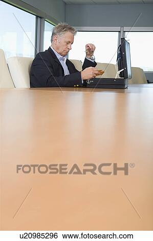 Stock Photograph - Serious Businessman with Open Briefcase. Fotosearch