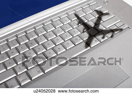 Stock Photo - Shadow of jumbo jet over apple macintosh keyboard. Fotosearch