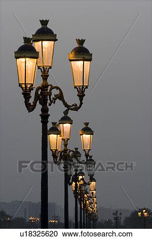 Stock Image - Sharjah UAE Lampposts glowing just after dark at Sharjah University City. Fotosearch