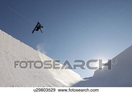 Stock Photo - Silhouette of teenage snowboarder on halfpipe. Fotosearch