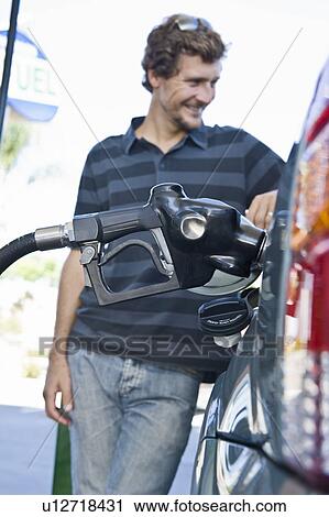 Smiling man refueling car at natural gas station View Large Photo Image Stock Image - Smiling man refueling car at natural gas station. Fotosearch