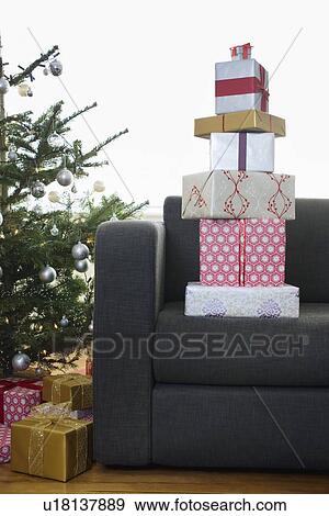 Stack of Christmas presents on armchair View Large Photo Image Stock Photo - Stack of Christmas presents on armchair. Fotosearch