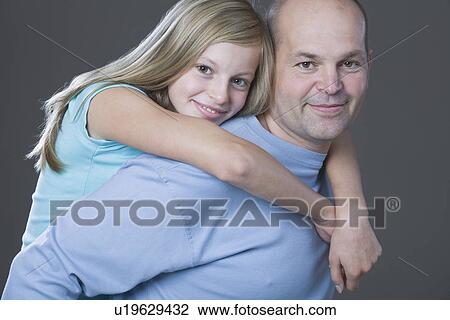 Studio portrait of daughter embracing father View Large Photo Image Stock Image - Studio portrait of daughter embracing father. Fotosearch