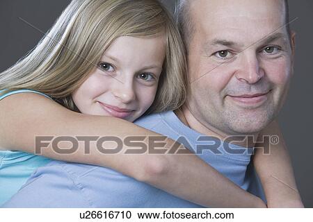 Studio portrait of daughter embracing father View Large Photo Image Stock Image - Studio portrait of daughter embracing father. Fotosearch