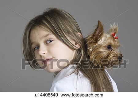 Stock Photo - Studio portrait of girl embracing dog. Fotosearch