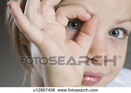 Studio portrait of girl peeking through hand close-up View Large Photo Image Stock Photograph - Studio portrait of girl peeking through hand close-up. Fotosearch