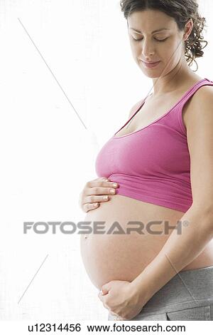 Stock Photograph - Studio portrait of pregnant woman. Fotosearch
