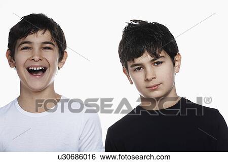 Stock Photograph - Studio portrait of twin boys (13-15) one laughing. Fotosearch