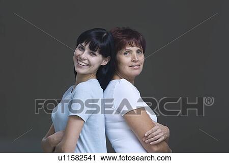 Studio portrait of young woman and mother back to back View Large Photo Image Stock Image - Studio portrait of young woman and mother back to back. Fotosearch