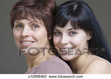 Studio portrait of young woman embracing mother View Large Photo Image Stock Image - Studio portrait of young woman embracing mother. Fotosearch