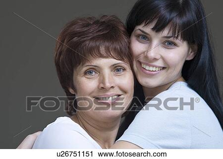 Studio portrait of young woman embracing mother View Large Photo Image Stock Image - Studio portrait of young woman embracing mother. Fotosearch