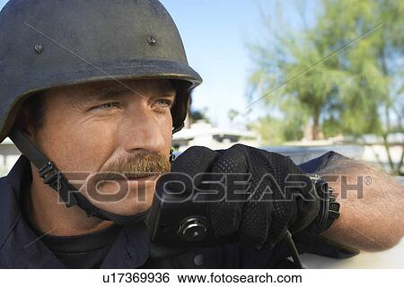 Stock Photograph - Swat officer using walkie-talkie. Fotosearch